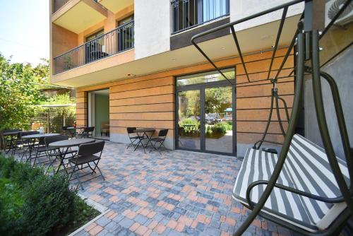 a patio with tables and chairs in front of a building at Hotel Avenue 30 in Yerevan