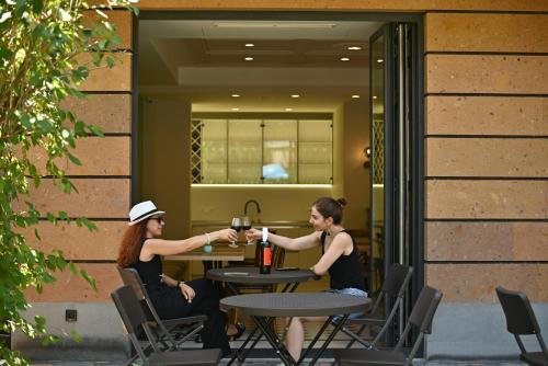 a man and woman sitting at a table with wine glasses at Hotel Avenue 30 in Yerevan