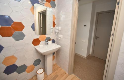 a bathroom with a sink and a mirror on a wall at Hotel Avenue 30 in Yerevan