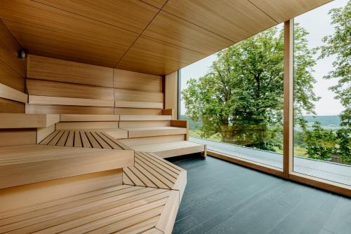 a sauna with wooden walls and a large window at Luisenhöhe - Gesundheitsresort Schwarzwald in Horben