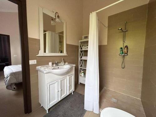 uma casa de banho com um lavatório, um chuveiro e um WC. em Casa Irene em Leporano