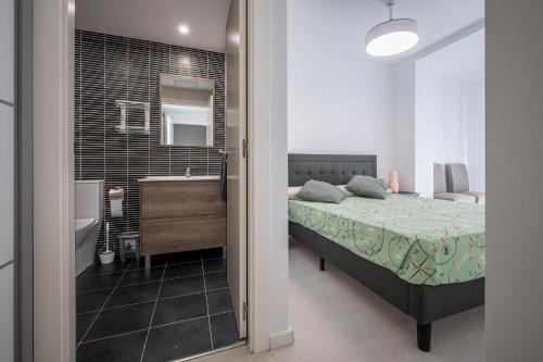 - une chambre avec un lit, un lavabo et un miroir dans l'établissement AT157 Nova Torredembarra II, à Torredembarra