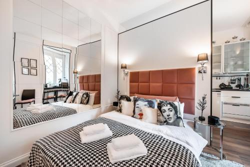 a bedroom with a large bed and a mirror at Premium Apart Varsovia Alice 2 in Warsaw