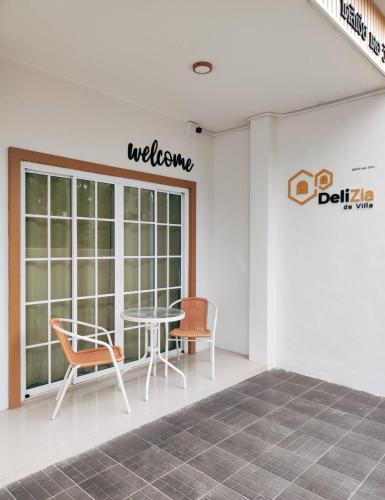 a room with a table and chairs and a window at DeliZia de Villa Satun พักได้ 9 ท่าน in Satun