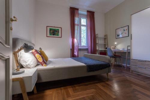Casa Dora by Wonderful Italy في تورينو: غرفة نوم مع سرير ومكتب مع مصباح