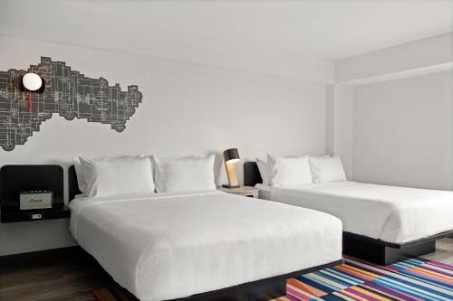 1 dormitorio con 2 camas y un mapa en la pared en Aloft Chicago Schaumburg en Rolling Meadows