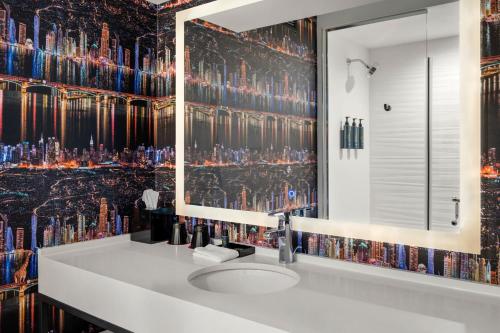 a bathroom with a sink and a mirror at Aloft Chicago Schaumburg in Rolling Meadows