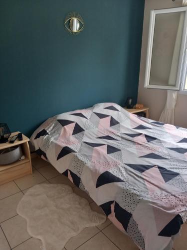 ein Schlafzimmer mit einem Bett mit einer Decke darauf in der Unterkunft Chez nous lo et val in Montpon-Ménestérol
