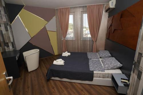 1 dormitorio con 1 cama con 2 toallas en апартамент Жаклин к.к. Хармони Хилс en Rogachevo