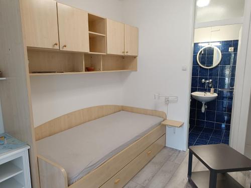 um pequeno quarto com uma cama e um lavatório em Apartmani Rameša em Murter