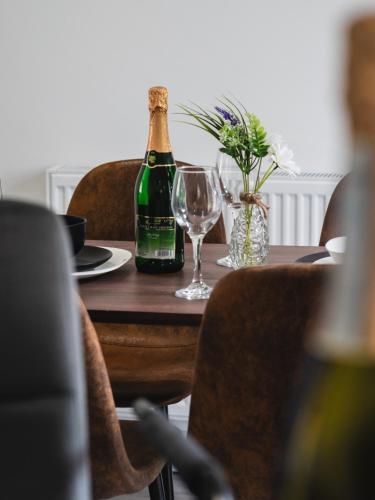 a bottle of champagne sitting on a table with glasses at Comfy Spacious Home Near Preston City Centre - Sleeps 6 in Samlesbury