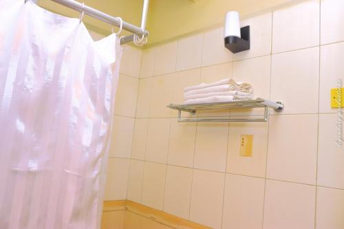 een badkamer met witte handdoeken en een handdoekenrek bij Jamia Central Hotel in Nairobi