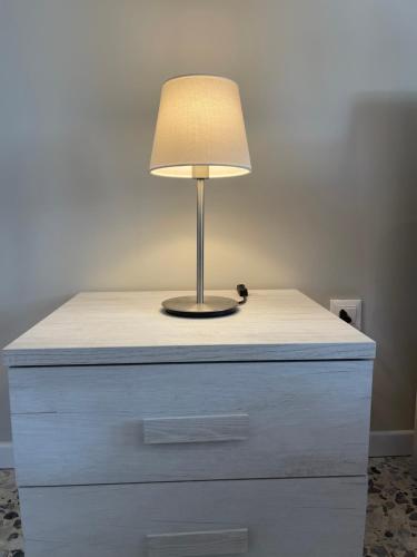 マントヴァにある[Lotus Home] eleganza e accoglienza a Mantovaのドレッサーの上にランプ付きテーブル