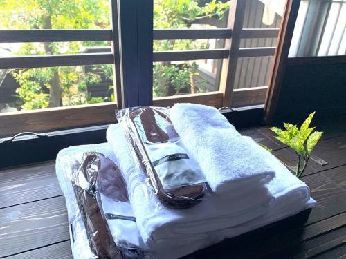 una cama sentada en un porche junto a una ventana en 庭の宿 帆や niwayado hoya, en Yaizu