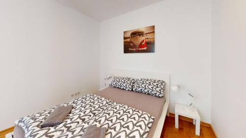 ein kleines Schlafzimmer mit einem Bett und einem Bild an der Wand in der Unterkunft Loftwohnung im tollen Hinterhaus in Leipzig