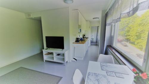 Habitación con TV, mesa y sillas. en Aparthotel Clock 19, en Kotka