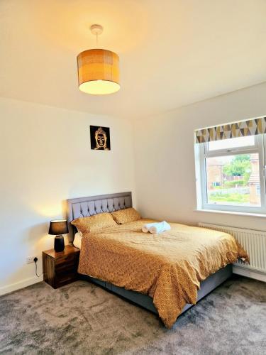a bedroom with a bed and a window at Comfy Spacious Home Near Preston City Centre - Sleeps 6 in Samlesbury