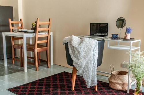 a desk with a laptop and a table with a chair at Tower Resident in the Heart of Bangkok Shopping Center in Makkasan