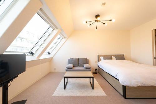 a bedroom with a bed and a chair and a tv at Fujiterrace Yoga in Tokyo