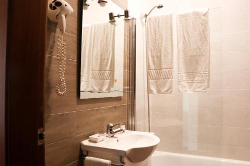 a bathroom with a sink and a toilet and a shower at Hotel Louro in Óbidos