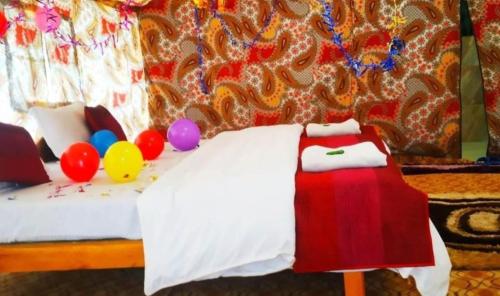 a bedroom with a bed with balloons and a table with a laptop at The Mountain Camp - Nubra in Hundar