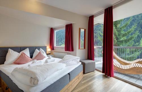 - une chambre avec un grand lit et une grande fenêtre dans l'établissement Villa Chiara, à Sankt Anton am Arlberg