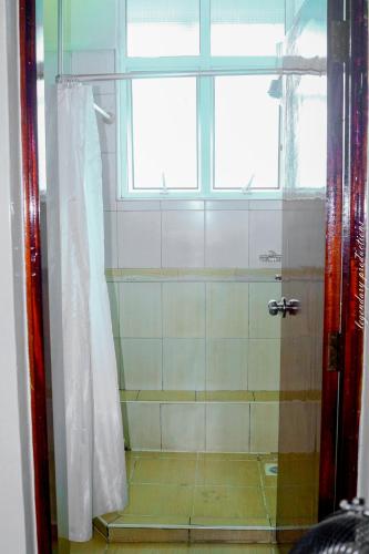 a bathroom with a shower with a window at Jamia Central Hotel in Nairobi