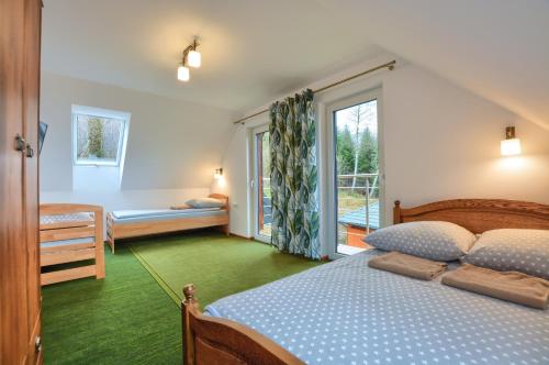 a bedroom with a bed and a window at Panskiemisie Domki Całoroczne sauna jacuzzi in Wetlina