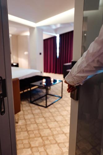 a room with a bed and a room with a table at Senator Hotel in Tirana