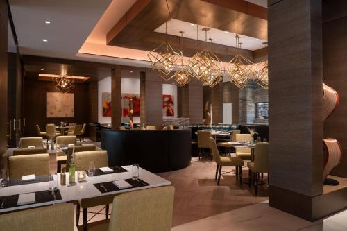 a restaurant with tables and chairs and chandeliers at The Westin Anaheim Resort in Anaheim