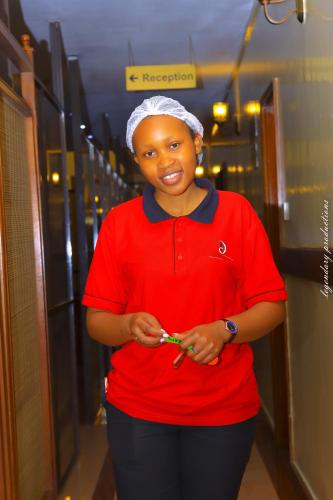 a woman in a red shirt holding a cell phone at Jamia Central Hotel in Nairobi