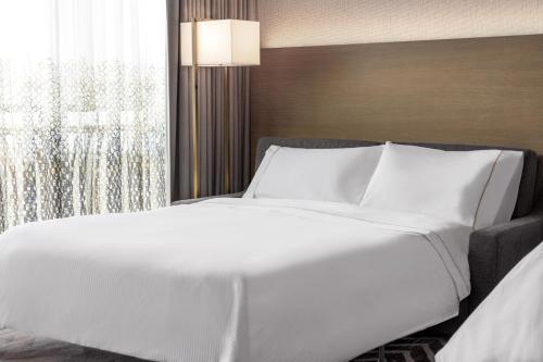 a large white bed in a room with a window at The Westin Anaheim Resort in Anaheim
