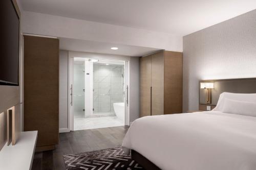 a bedroom with a bed and a bathroom with a tub at The Westin Anaheim Resort in Anaheim
