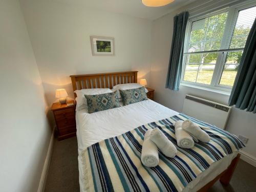 a bedroom with a bed with towels on it at Seagull Leigh Cottages in Seaton