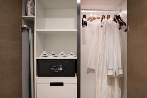 a walk in closet with white clothes and a microwave at The Westin Anaheim Resort in Anaheim