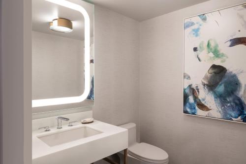 a white bathroom with a sink and a mirror at The Westin Anaheim Resort in Anaheim