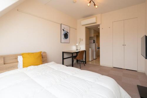 a bedroom with a white bed and a desk at Fujiterrace Yoga in Tokyo