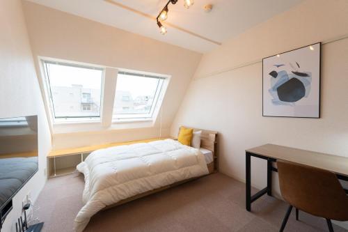 a bedroom with a bed and a desk and window at Fujiterrace Yoga in Tokyo