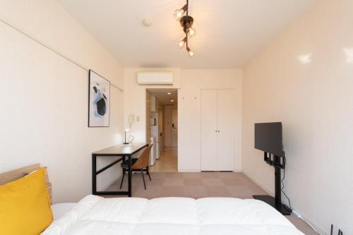 a bedroom with a bed and a desk and a television at Fujiterrace Yoga in Tokyo