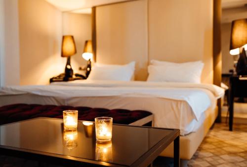 a hotel room with a bed with two glasses on a table at Senator Hotel in Tirana