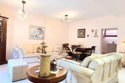 a living room with white furniture and a table at Fairytale apartment in Agios Ioannis