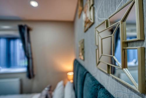 eine Reihe von Spiegeln an einer Wand in einem Raum in der Unterkunft Stylish House - B'ham Airport and NEC, JLR Solihull, Business & Leisure Stays - Aspen House in Solihull