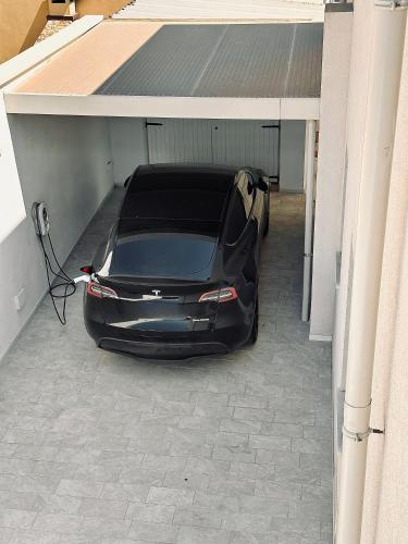 a black car is parked in a garage at Villa Noga Rooms in Selargius
