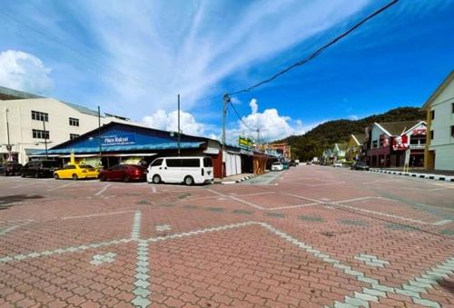 a street with cars parked in a parking lot at Dindings Pantai Desair Apartment By DPD in Lumut