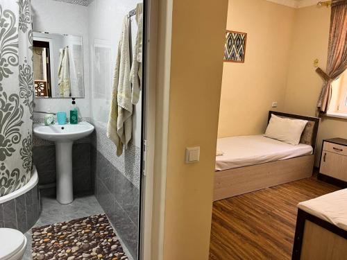 a small bathroom with a bed and a sink at Ikat Terrace in Bukhara