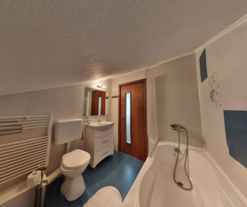 La salle de bains blanche est pourvue d'une baignoire et de toilettes. dans l'établissement Modern 3-bedroom place in Ramnicu Valcea, à Râmnicu Vâlcea
