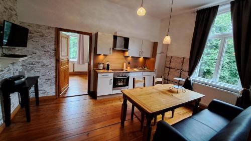 ein Wohnzimmer mit einem Tisch und einer Küche in der Unterkunft Haus im Park in Wesselburen