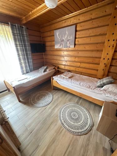a room with two beds in a log cabin at Osada Barbanica in Szczyrk