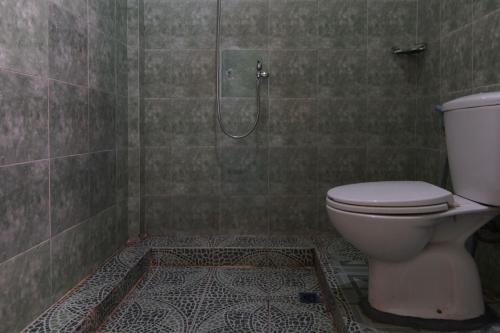 y baño con ducha y aseo. en OYO 92924 Kalista Guest House Syariah, en Pekanbaru