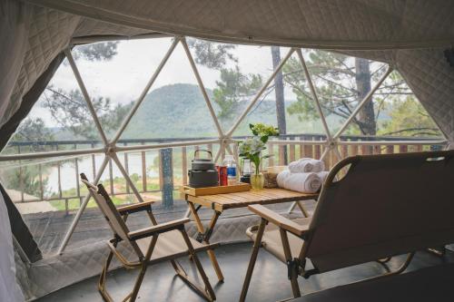 a room with a table and chairs in a tent at Lavender Dalat Hotel and Resorts in Da Lat